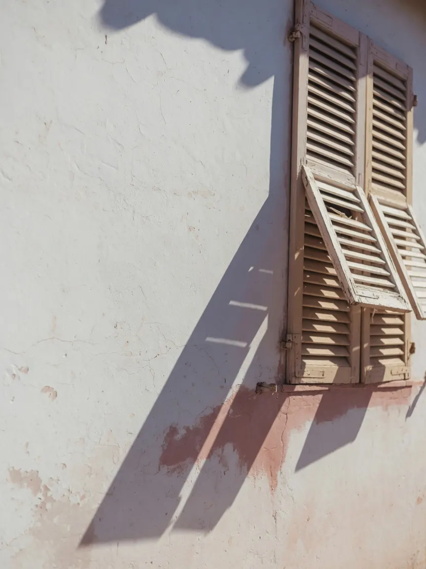 Hard midday sun on weathered stucco — the cumulative sun exposure Tampa surfaces record