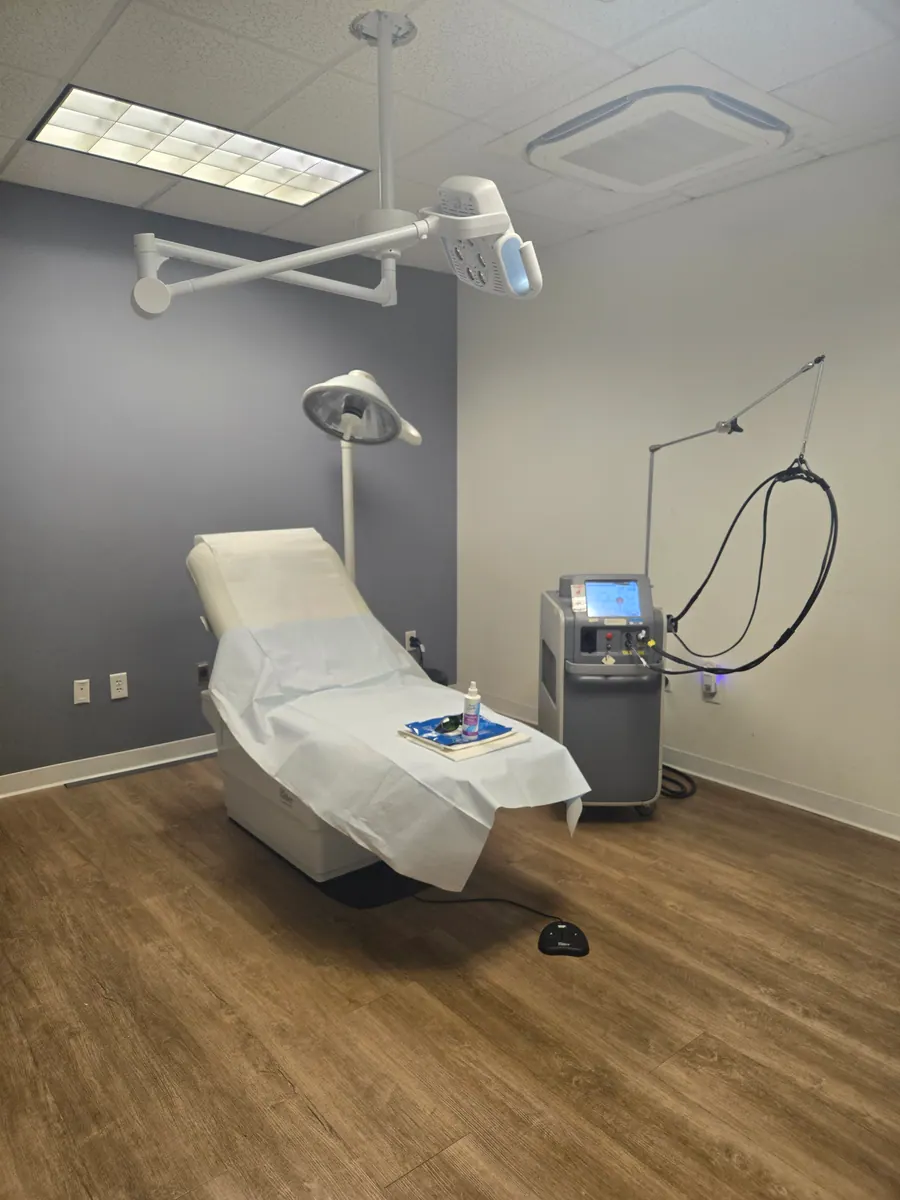 A laser treatment room with medical-grade device and exam lamp