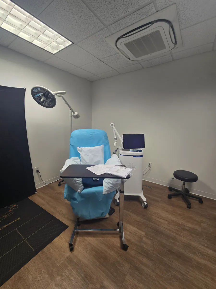 A treatment suite with teal contour chair and monitor